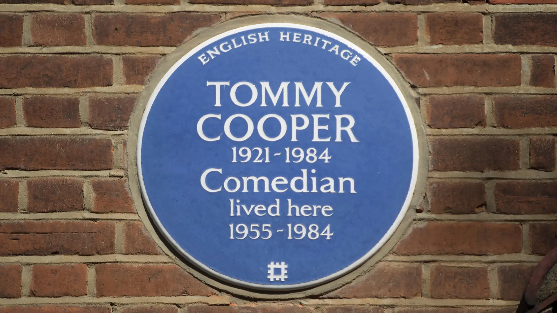 Een blauwe plaquette op de gevel van het huis van Cooper.